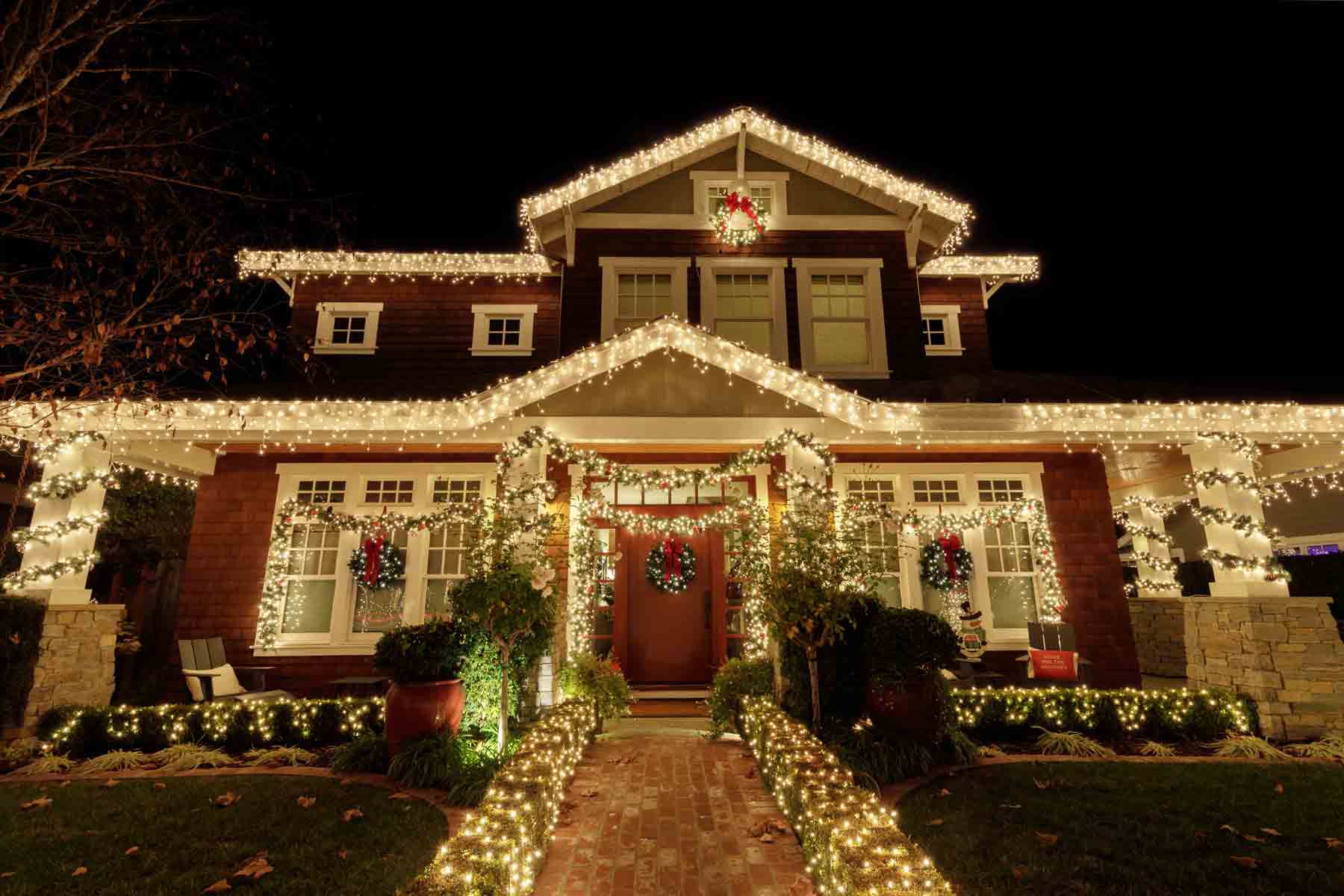 An elegant Christmas light installation on a two-story house and front yard An elegant Christmas light installation on a two-story house and front yard