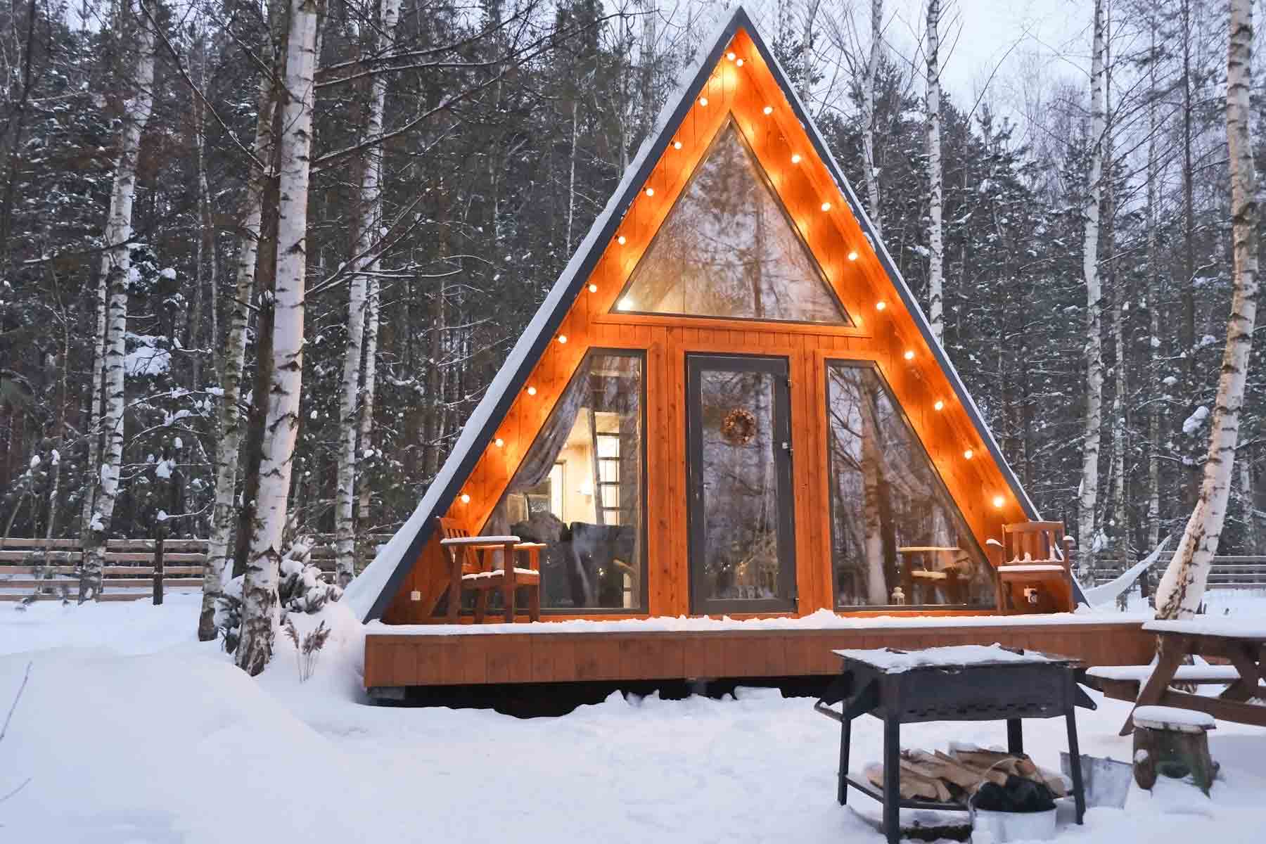 An A-frame cabin in the snow.