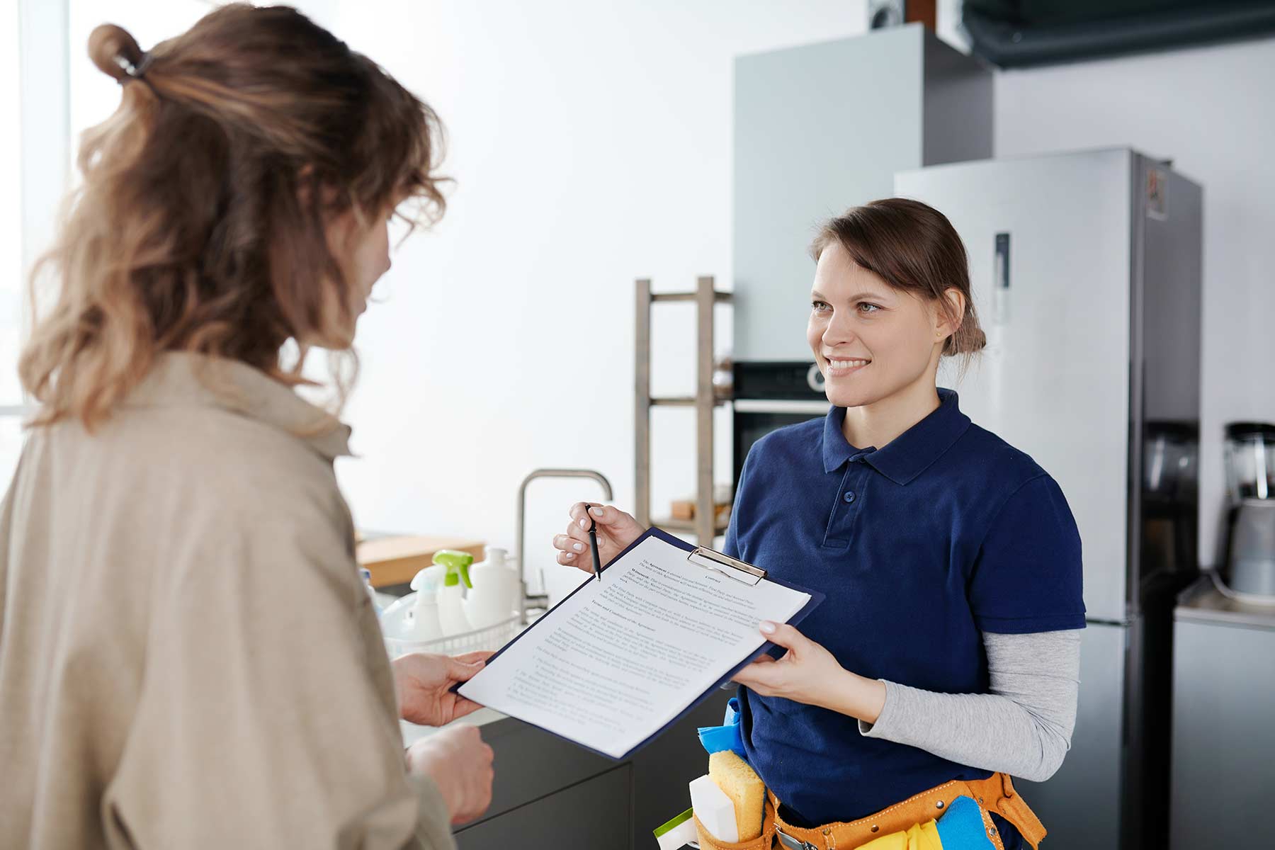 A cleaning service worker discussing the terms of contract with a client A cleaning service worker discussing the terms of contract with a client
