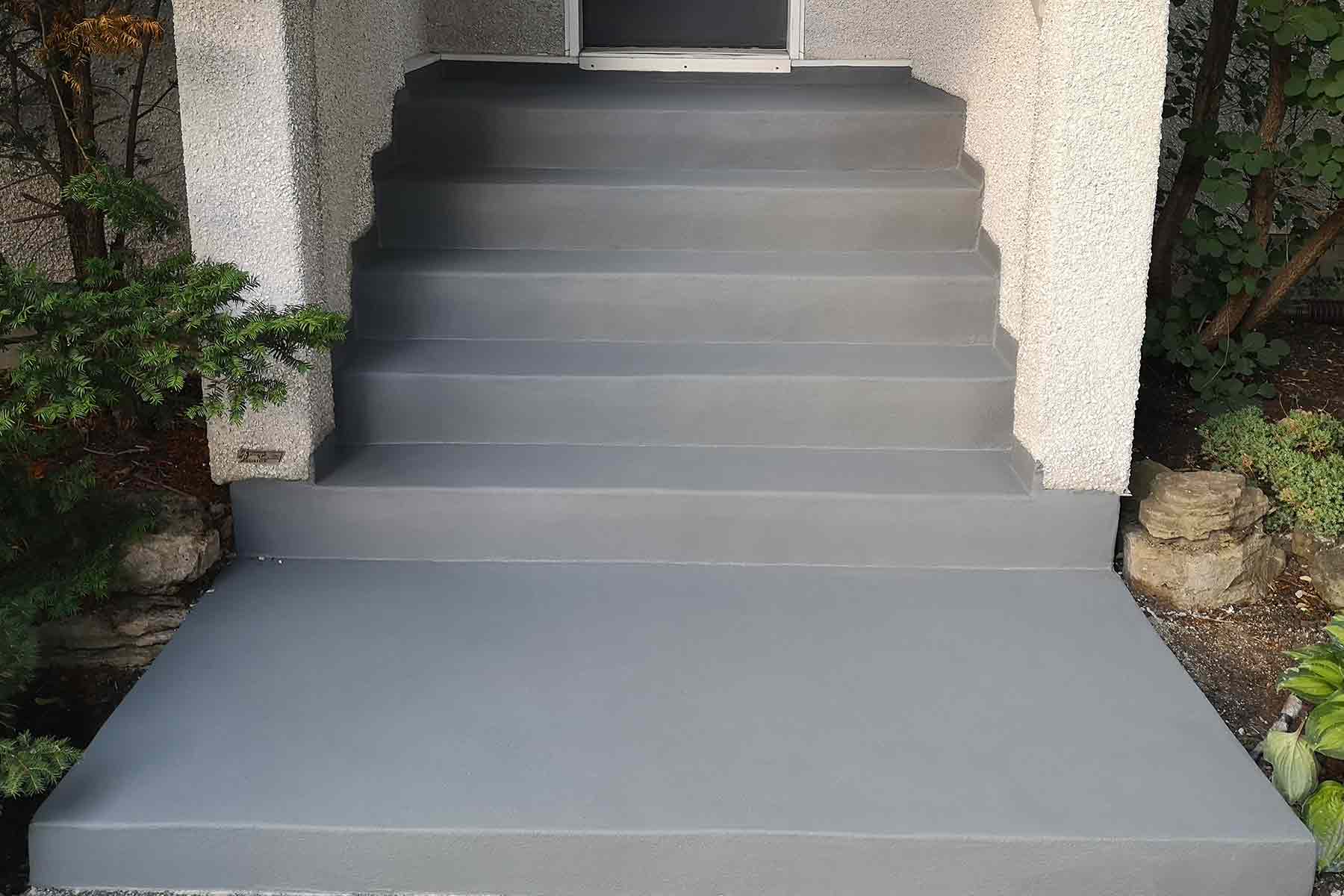 Newly repaired concrete steps with a dark gray finish