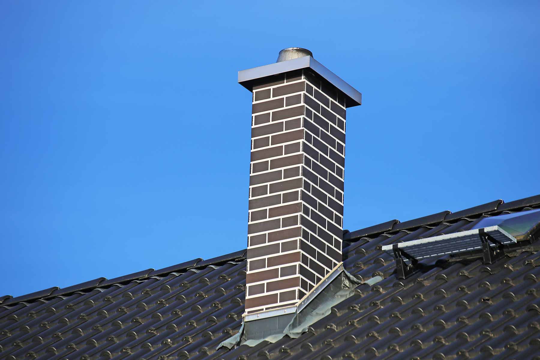 Close-up of a newly built brick chimney on a residential house roof