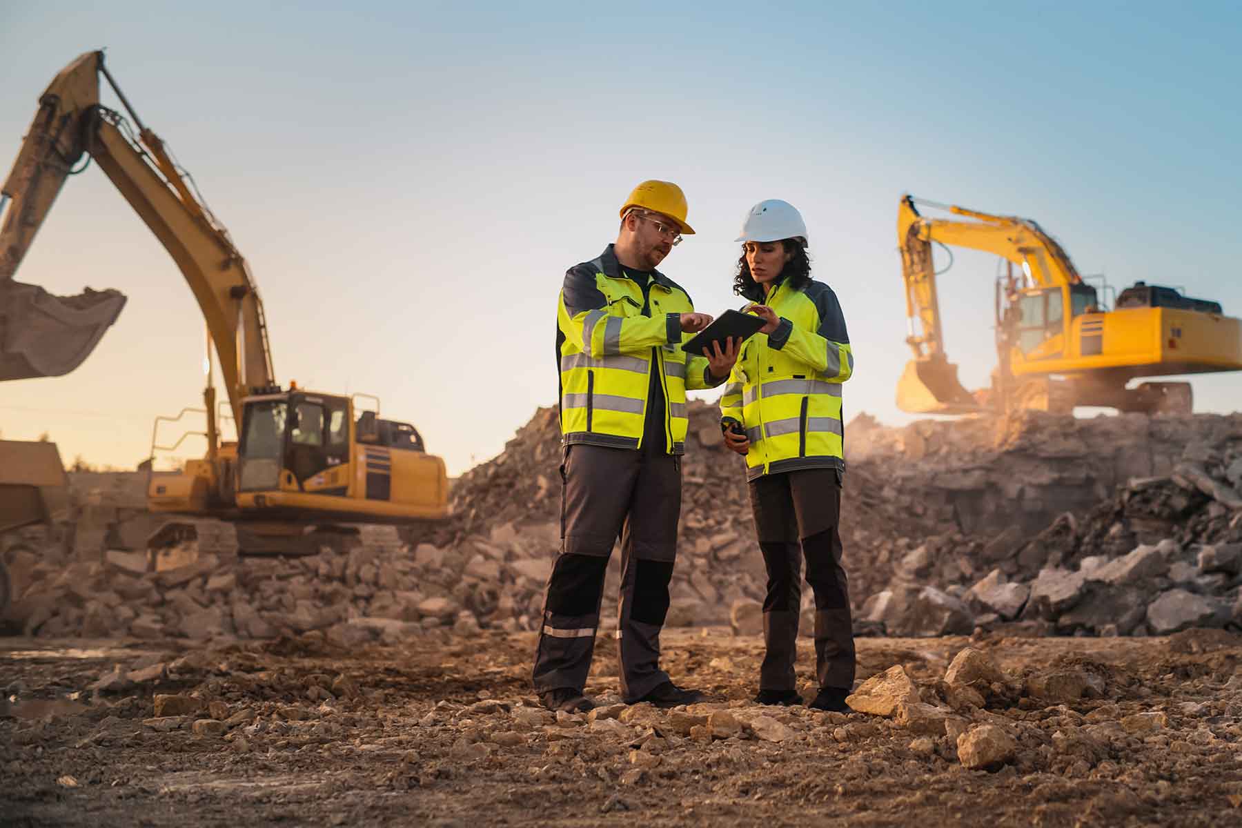 Civil engineer and site inspector reviewing plans on new housing site Civil engineer and site inspector reviewing plans on new housing site