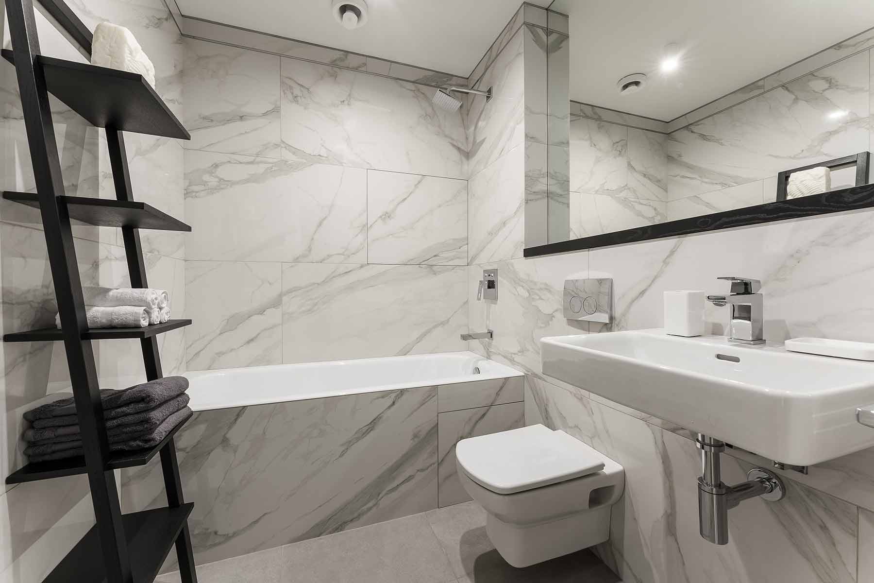 Interior of a modern white marble bathroom inside a basement