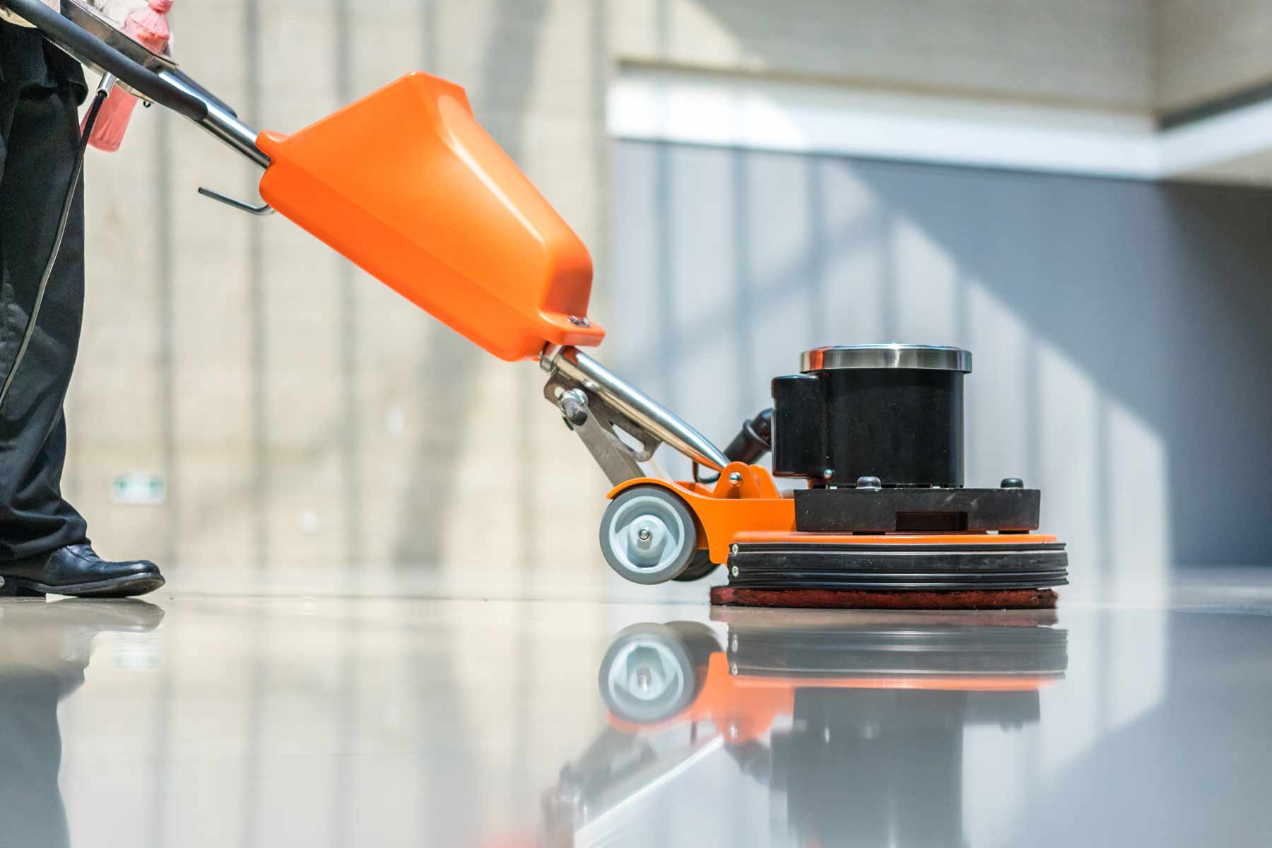 A floor cleaning technician stripping and waxing a commercial floor