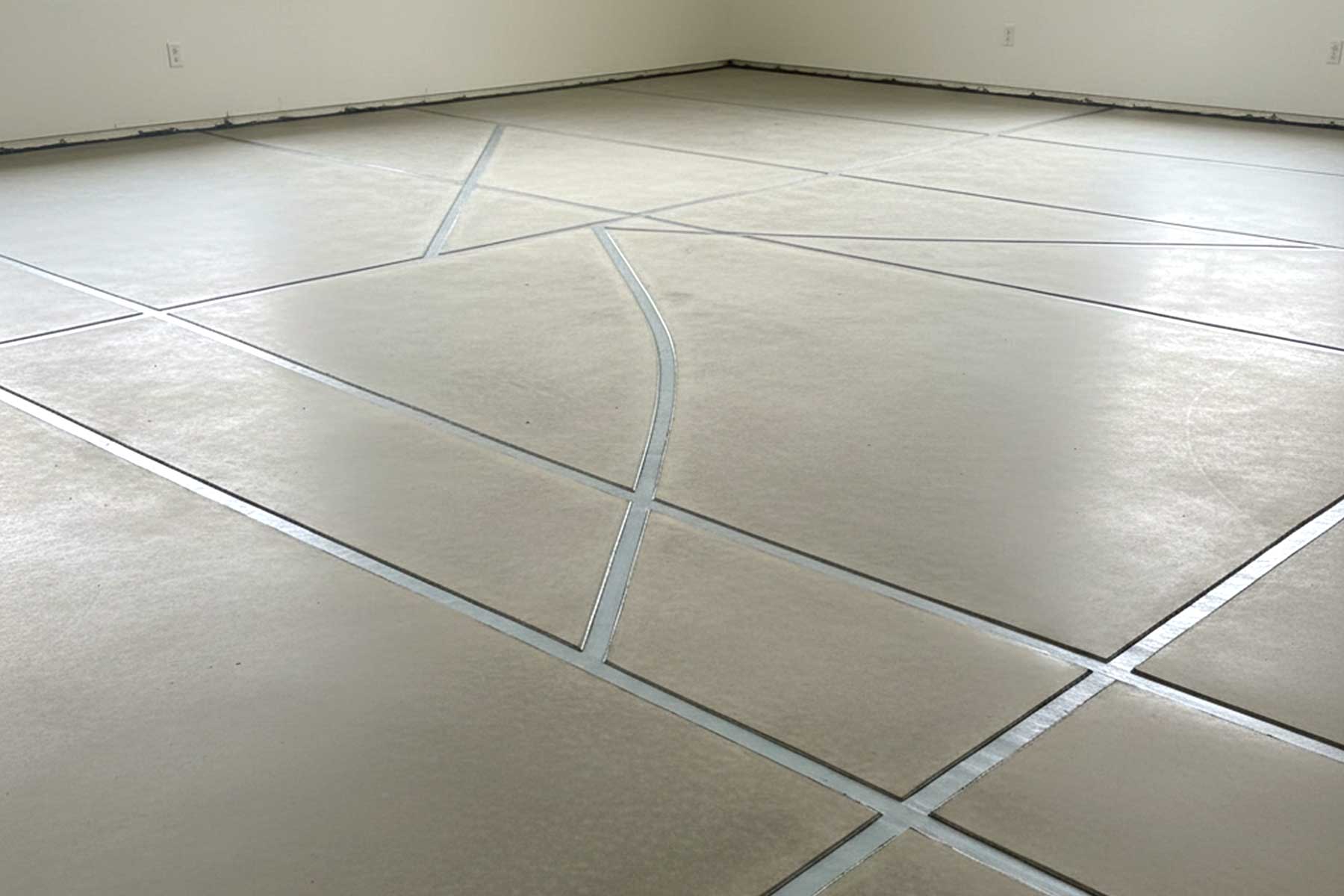 A newly repaired slab foundation with visible cracks sealed with epoxy and polyurethane injections
