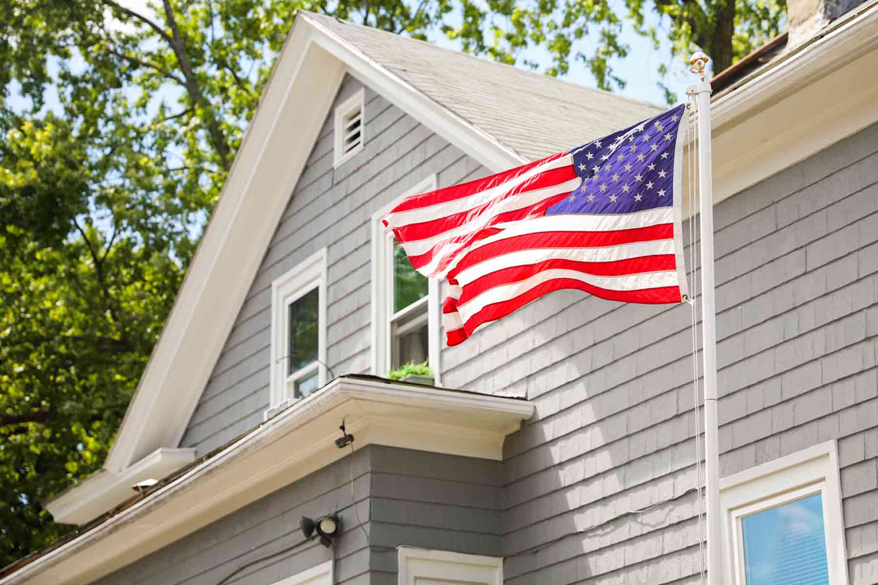 American flag waving on a tall flagpole in a residential house