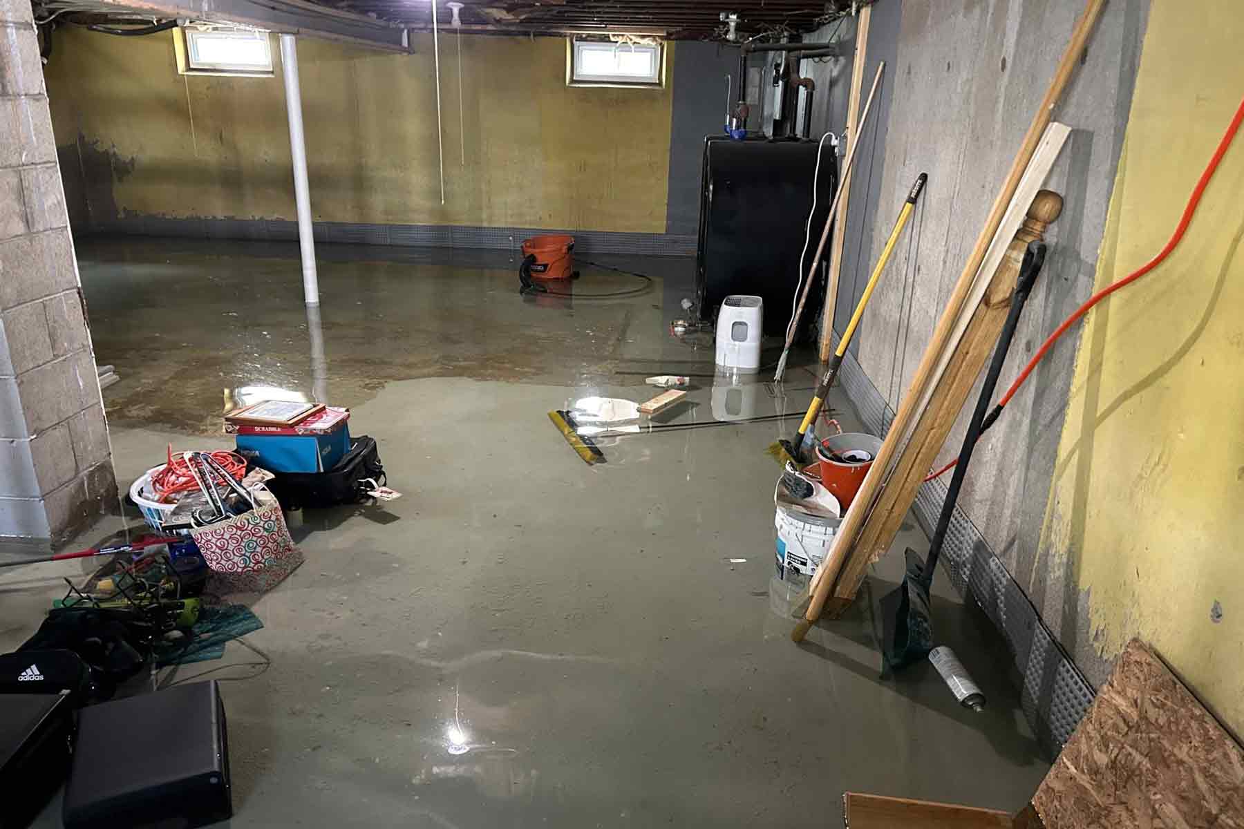 A flooded basement with water on the floor in a home (Photo credit: Drycrete Waterproofing)