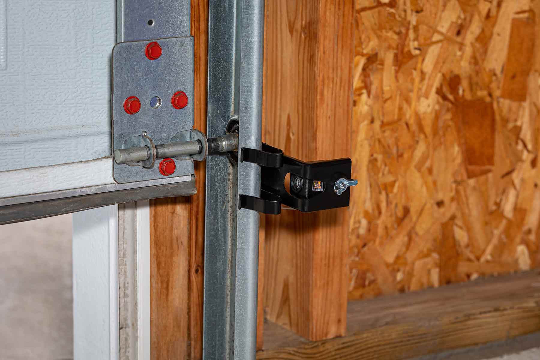 An overhead garage door opener safety sensor installed on roller track