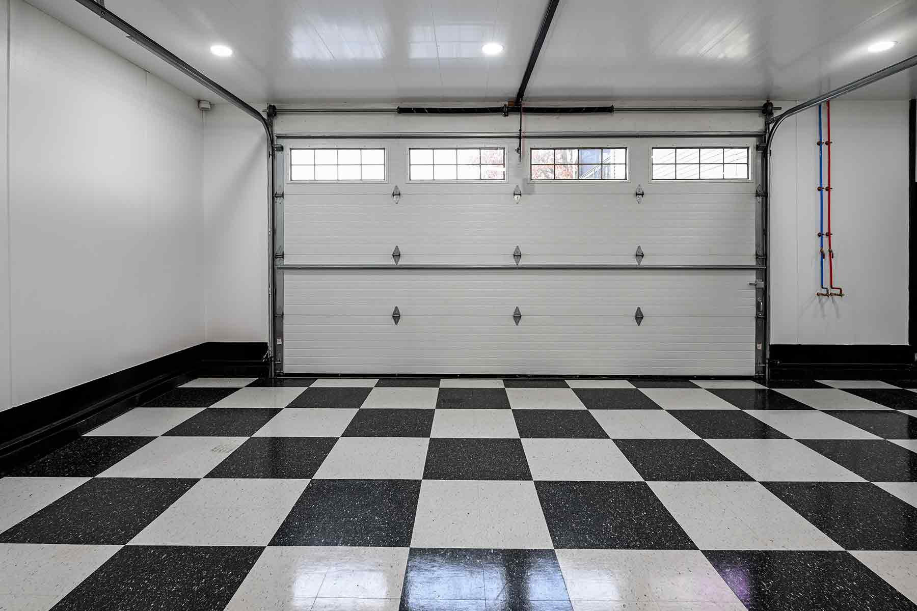 Interior of a newly repaired garage floor with black and white checkered tile pattern
