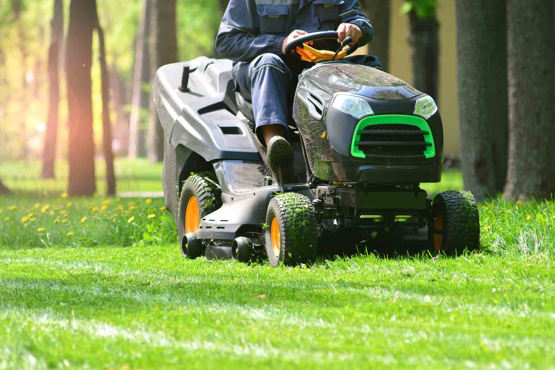 A lawn mowing professional cutting grass with a riding lawn mower A lawn mowing professional cutting grass with a riding lawn mower