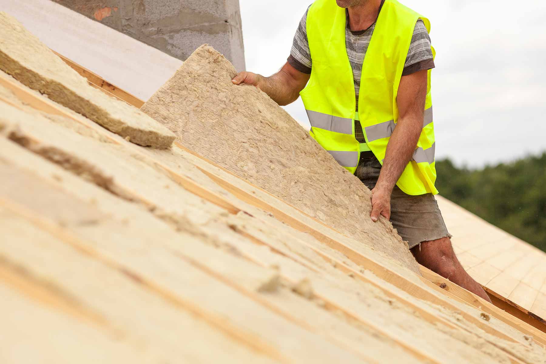 A roofing contractor installing roof insulation panels