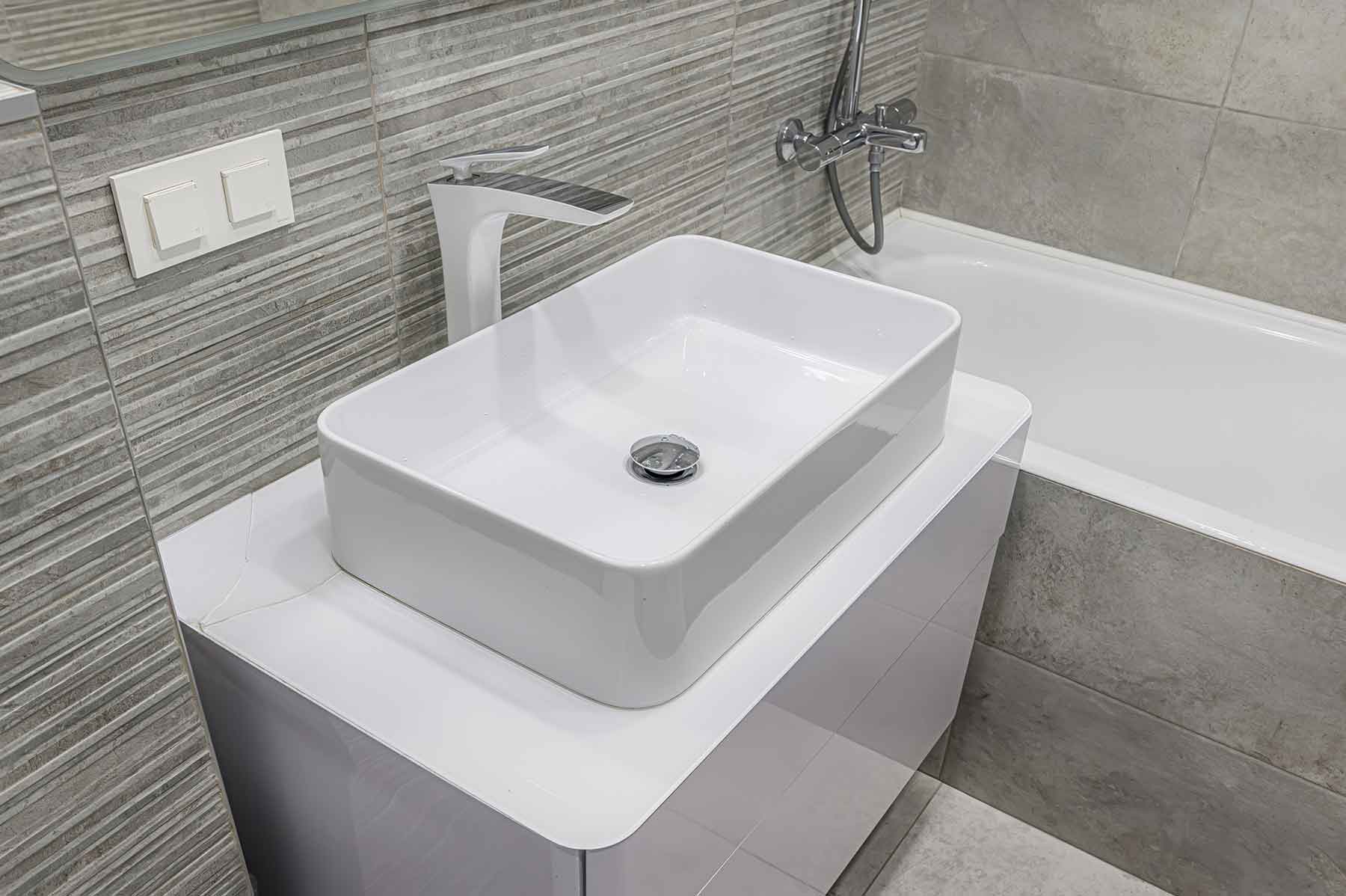 A newly refinished white ceramic bathroom sink with a modern faucet