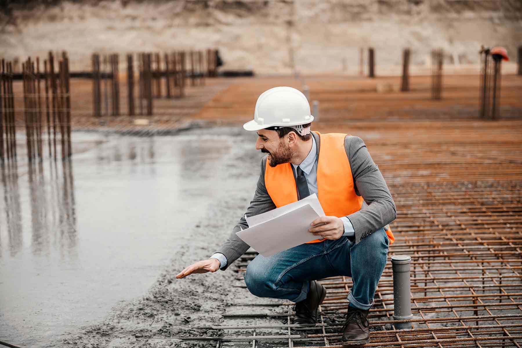 Contractor inspecting a new concrete slab construction